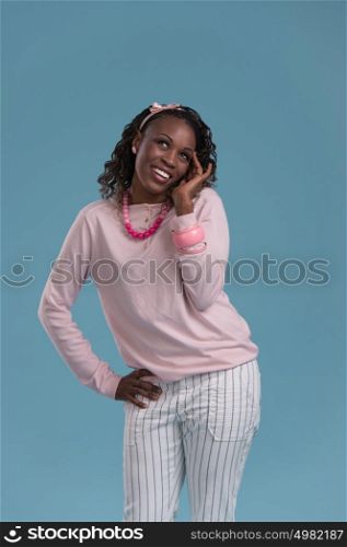 Portrait of a beautiful African young woman thinking on blue background