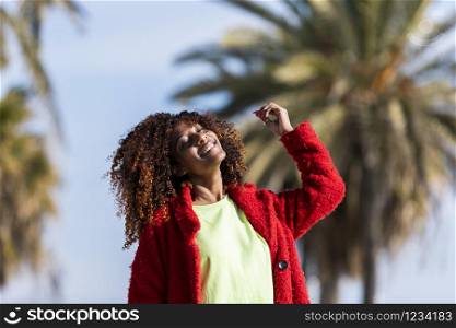 Portrait of a beautiful afro american woman standing in the street in a sunny day