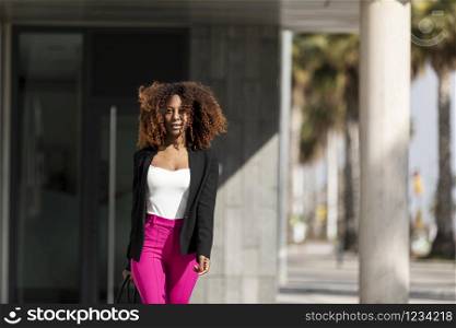 Portrait of a beautiful afro american woman standing in the street in a sunny day
