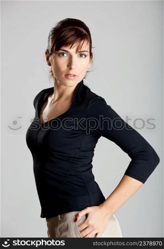 Portrait of a beautiful and fashion young woman isolated over a gray background