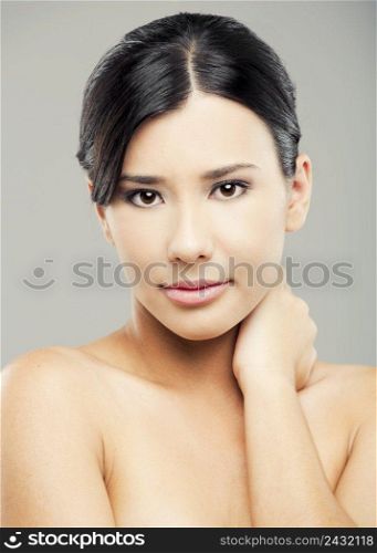Portrait of a beautiful and sexy asian woman, over a gray background.