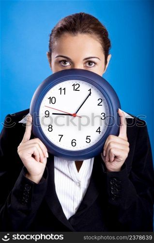 Portrait of a beautiful and young businesswoman holding a clock 