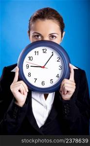 Portrait of a beautiful and young businesswoman holding a clock 