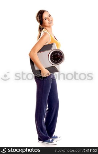 Portrait of a beautiful athletic girl holding a scale, isolated on white