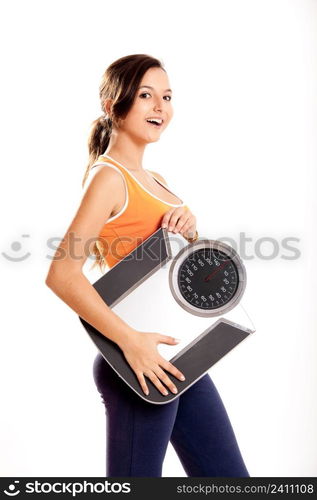 Portrait of a beautiful athletic girl holding a scale, isolated on white