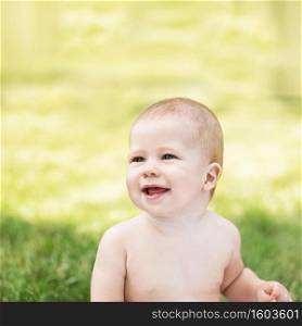 Portrait of a beautiful baby against green nature background outdoors