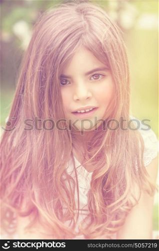 Portrait of a beautiful baby girl with long hair, enjoying spring outdoors, vintage style photo, authentic natural beauty of a kid, genuine look