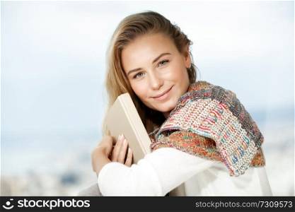 Portrait of a beautiful blond woman with pleasure reading book at home, enjoying romantic story, happy carefree domestic life