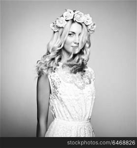 Portrait of a beautiful blonde woman with flowers in her hair. Fashion photo