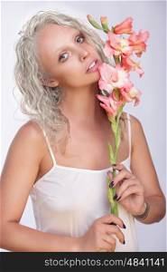 Portrait of a beautiful blonde woman with lily flower in hand. Stylish.