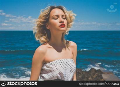 Portrait of a beautiful blonde young lady at the sea