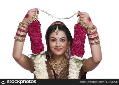 Portrait of a beautiful bride holding a garland