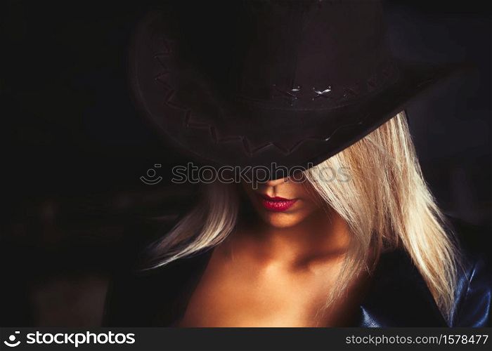 Portrait of a beautiful bright blond haired girl with caountry hat.