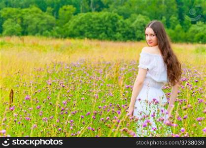 portrait of a beautiful brunette in a field of purple flowers