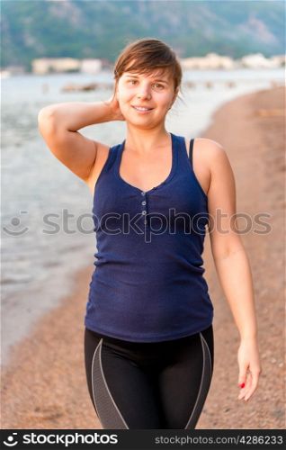 portrait of a beautiful brunette on the beach early in the morning