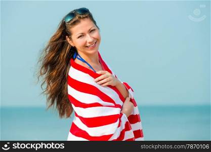portrait of a beautiful brunette with a towel on the beach