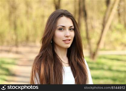 portrait of a beautiful brunette woman outdoors in the park