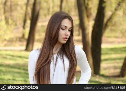 portrait of a beautiful brunette woman outdoors in the park
