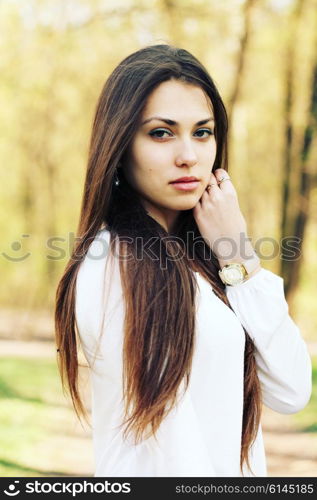 portrait of a beautiful brunette woman outdoors in the park