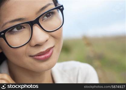 Portrait of a beautiful chinese asian girl or young woman outside wearing glasses