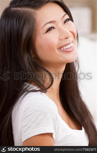 Portrait of a beautiful chinese oriential asian young woman with perfect teeth smiling and laughing