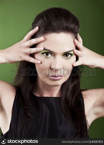 Portrait of a beautiful fashion woman over a green background
