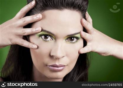 Portrait of a beautiful fashion woman over a green background
