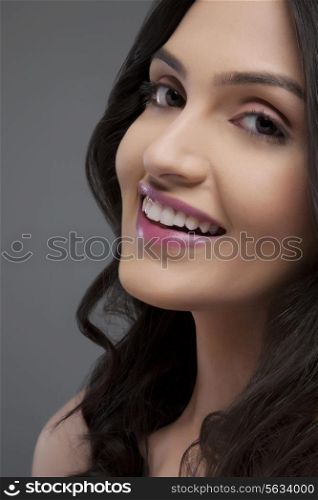 Portrait of a beautiful female smiling over colored background