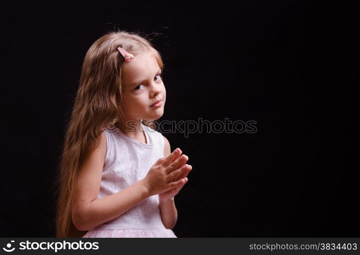 Portrait of a beautiful five year old girl on a black background