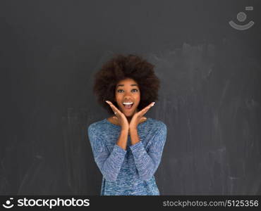 portrait of a beautiful friendly African American woman with a curly afro hairstyle and lovely smile isolated on a gray background