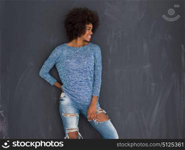 portrait of a beautiful friendly African American woman with a curly afro hairstyle and lovely smile isolated on a gray background