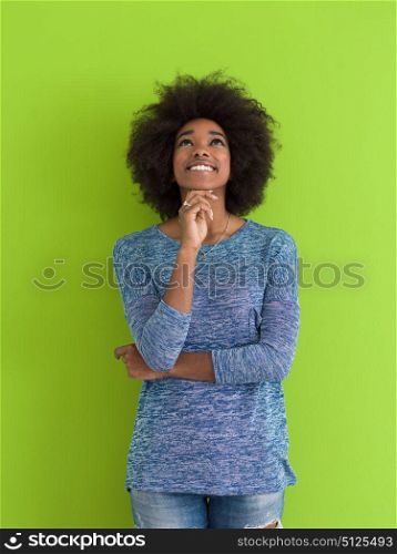portrait of a beautiful friendly African American woman with a curly afro hairstyle and lovely smile isolated on a Green background