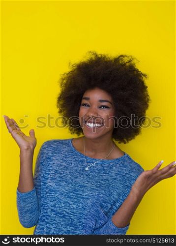 portrait of a beautiful friendly African American woman with a curly afro hairstyle and lovely smile isolated on a Yellow background