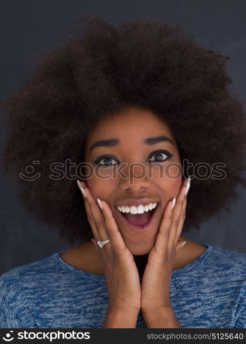 portrait of a beautiful friendly African American woman with a curly afro hairstyle and lovely smile isolated on a gray background