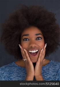 portrait of a beautiful friendly African American woman with a curly afro hairstyle and lovely smile isolated on a gray background