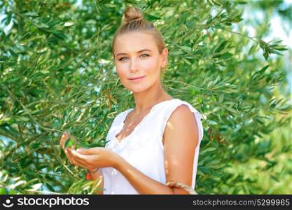 Portrait of a beautiful gentle girl enjoying olive garden, picking autumn harvest, cultivation of organic fruits, healthy life in a countryside