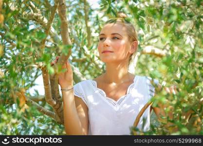 Portrait of a beautiful gentle girl in olive garden, picking autumn harvest, cultivation of fruits, healthy life in a countryside