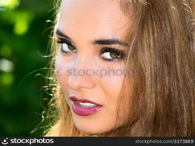 Portrait of a beautiful girl against a green floral background