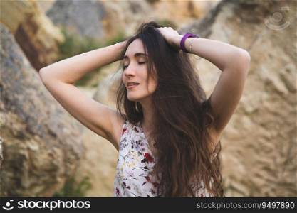 portrait of a beautiful girl holding her hands by her hair outdoors