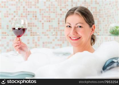 portrait of a beautiful girl in a bath with a glass
