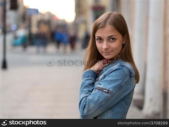 portrait of a beautiful girl in a jeans jacket on the street at night