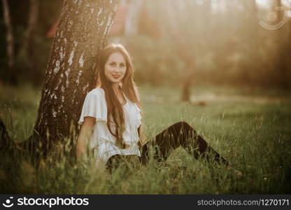 Portrait of a beautiful girl in a park at sunset. Pretty girl with sweater outdoors in fall smiling. Portrait of a beautiful girl in a park at sunset. Portrait of a beautiful girl in a park at sunset. Pretty girl with sweater outdoors in fall smiling.