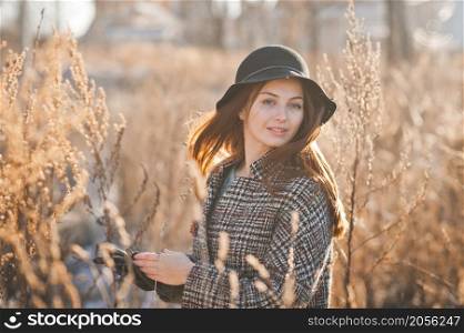 Portrait of a beautiful girl in the reeds in spring and wearing a hat.. A girl in the reeds on an early spring day 3501.