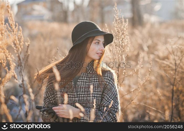 Portrait of a beautiful girl in the reeds in spring and wearing a hat.. A girl in the reeds on an early spring day 3502.