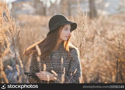 Portrait of a beautiful girl in the reeds in spring and wearing a hat.. A girl in the reeds on an early spring day 3502.