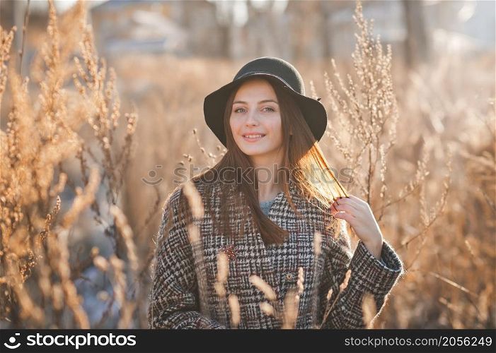 Portrait of a beautiful girl in the reeds in spring and wearing a hat.. A girl in the reeds on an early spring day 3503.