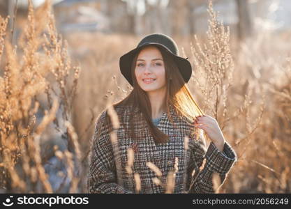 Portrait of a beautiful girl in the reeds in spring and wearing a hat.. A girl in the reeds on an early spring day 3503.