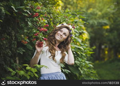 Portrait of a beautiful girl near the Bush of the mountain ash.. Portrait of a girl with a wreath on his head in the garden 4797.