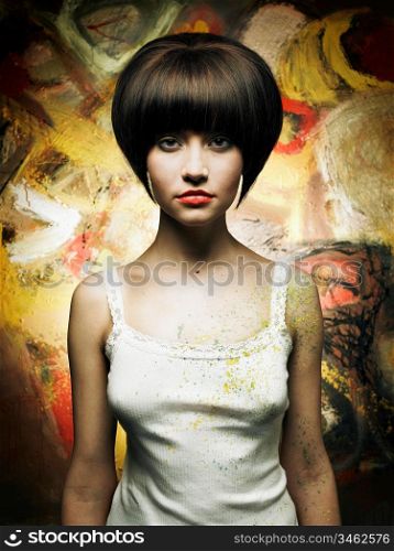Portrait of a beautiful girl on a background of abstract painting