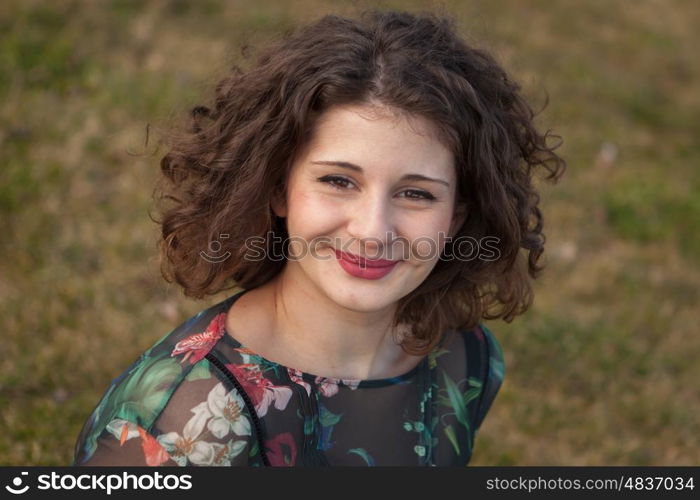 Portrait of a beautiful girl with curly hair in the landscape